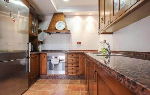 a kitchen with a sink and a clock on the wall at Cozy Home In Orihuela in Orihuela