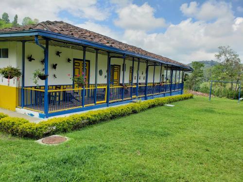 a yellow and blue building with a grass field at El Rancho de Salento in Salento