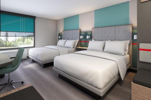 um quarto de hotel com duas camas e uma secretária em Avid Hotels - Cincinnati N - West Chester, an IHG Hotel em West Chester