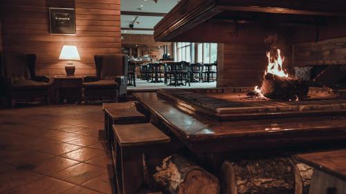 a fireplace in a restaurant with a fire in it at Wyndham Garden Ushuaia Hotel del Glaciar in Ushuaia