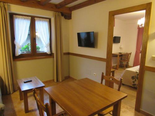 a living room with a table and a dining room at Apartamentos El Haya in Cosgaya