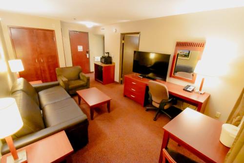 a hotel room with a couch and a desk and a television at Canad Inns Destination Centre Fort Garry in Winnipeg