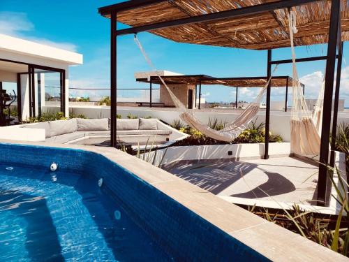 a villa with a swimming pool and a hammock at Meliora by Bunik in Playa del Carmen