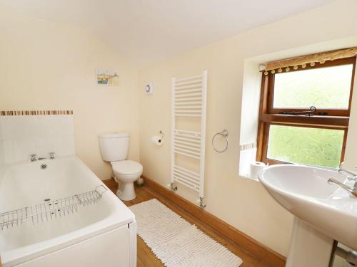 a bathroom with a tub and a sink and a toilet at Wolds View in Cornisholme