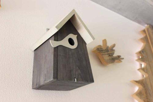 a birdhouse hanging on a wall with a mask at Apartment Monolith Black Forest in Schonach