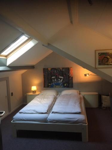a bed in a attic room with a roof at B n B nr. 1 in Apeldoorn