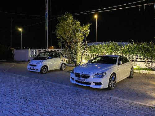 two cars parked in a parking lot at night at Hotel La Maison Delle Terme in Tivoli Terme