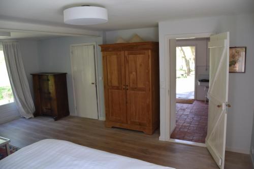 a bedroom with a bed and a wooden cabinet at Cottage Duinroos - Dune Rose in Oostvoorne