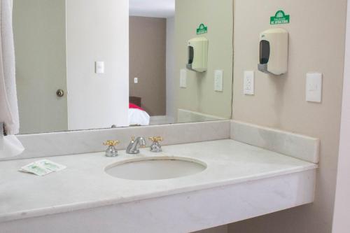 y baño con lavabo y espejo. en Hotel Huizache en Saltillo