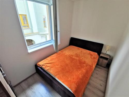 Cama pequeña en habitación con ventana en Exclusive Home - D. apartman, en Pécs
