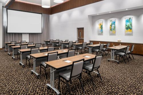 a classroom with tables and chairs and a projection screen at Hyatt Place Atlanta/Perimeter Center in Atlanta