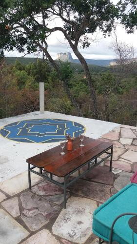 a wooden table with two wine glasses on top of a table at Morada dos Elfos in Vale do Capao