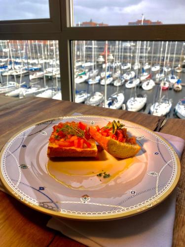 a plate with two pieces of food on a table with a marina at Scheveningen Diamond View Beach and Harbour in Scheveningen