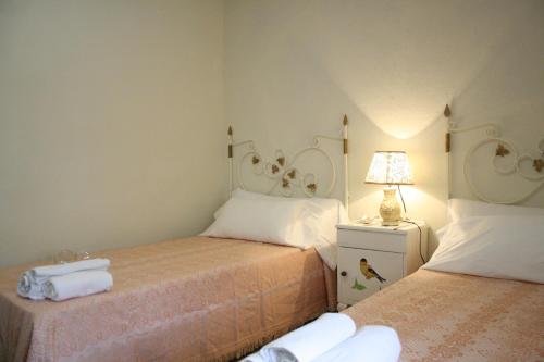 a bedroom with two beds and a lamp on a night stand at Apts la cañada birding con encanto y patio en monfrague torrejon el Rubio in Torrejón el Rubio