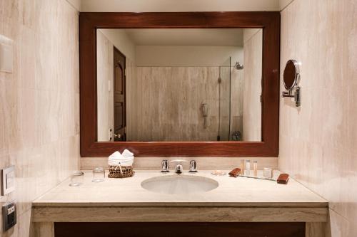 a bathroom with a sink, mirror, and bathtub at Wyndham Costa del Sol Arequipa in Arequipa