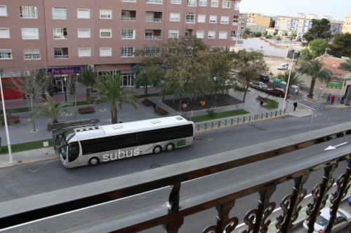 een bus staat geparkeerd in een stadsstraat bij Hotel Doña Isabel in Torrellano