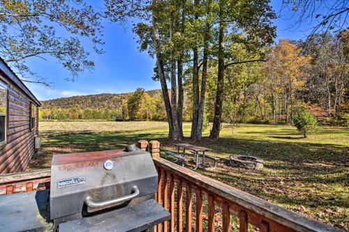 a grill on a deck with a view of a park at Rural Cabin Hideaway with Fire Pit and Mtn Views! in Parsons