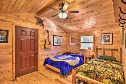 Dormitorio en cabaña de madera con cama y guitarra en Pet-Friendly Cabin with Fire Pit and River Access!, en Parsons