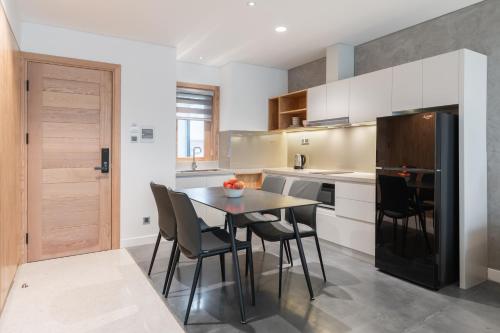 a kitchen with a table and chairs and a refrigerator at Bi Eco Suites Hanoi in Hanoi