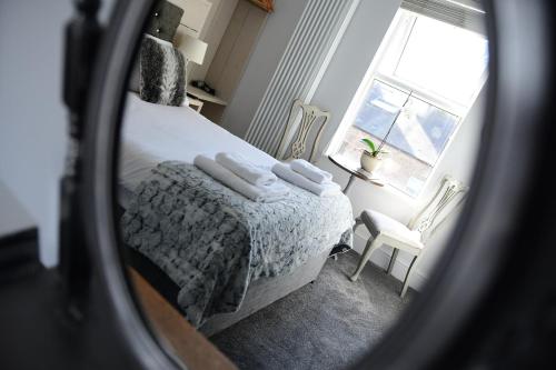 a reflection of a bedroom with a bed and a window at Vikings Accommodation in York