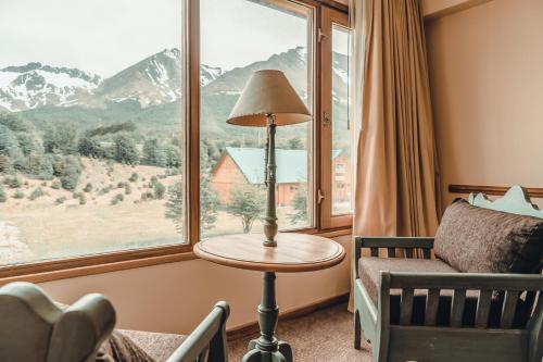 a room with a bed and a table and a window at Wyndham Garden Ushuaia Hotel del Glaciar in Ushuaia