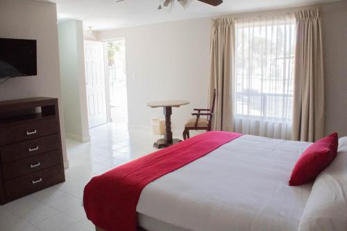 a bedroom with a bed and a dresser and a television at Hotel Huizache in Saltillo