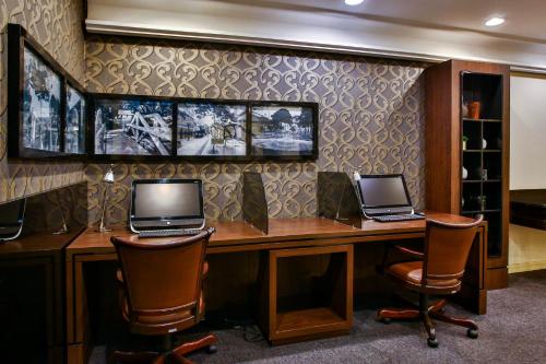 a office with two laptops on a desk with two chairs at Transamerica Executive Curitiba Batel in Curitiba