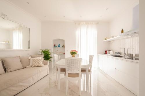 a white living room with a couch and a table at Porta Piccola Luxury Home in Bari