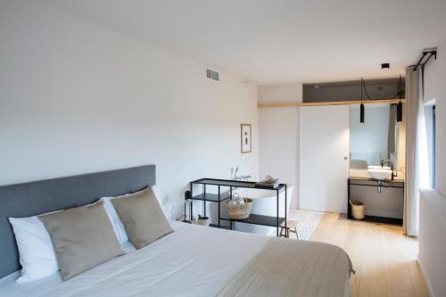1 dormitorio con cama blanca y baño en Hotel Rural Mas de l'Illa en Tivissa