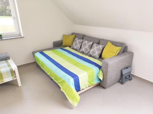 a bed in a room with a couch with a blanket at Ferienwohnung Karola beim Legoland in Ichenhausen