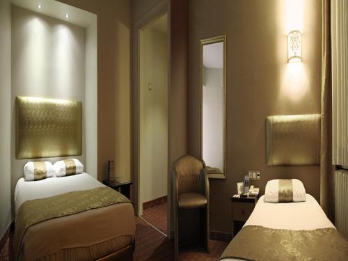ブルサにあるホテル アーティスのベッド2台と鏡が備わるホテルルームです。