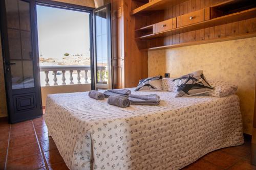 a bedroom with a bed with a large window at VILLA LAS CUEVAS in Tías