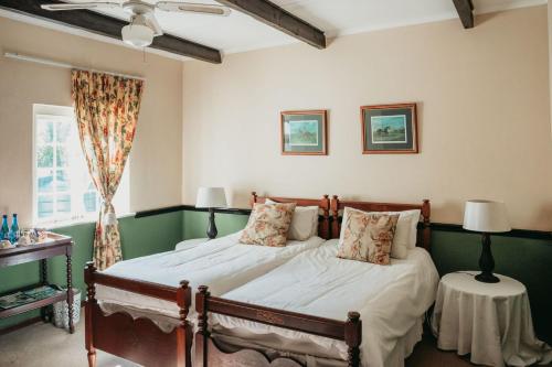 a bedroom with two beds and a window at The Historic Pig and Whistle Inn in Bathurst