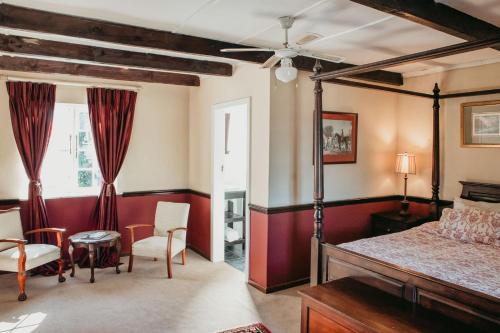 a bedroom with a bed and a chair and a table at The Historic Pig and Whistle Inn in Bathurst