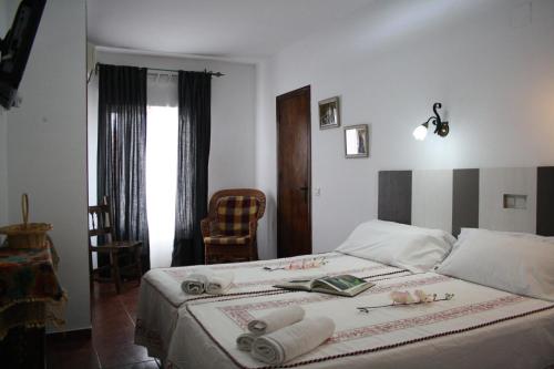 ein Schlafzimmer mit einem Bett mit zwei Büchern darauf in der Unterkunft Alojamiento la cañada monfrague in Torrejón el Rubio