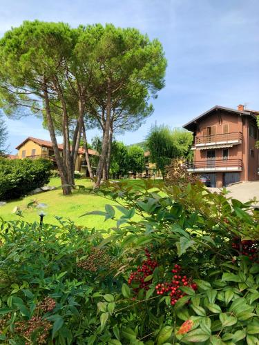 a park with trees and bushes and a building at Green Apartment in Albavilla