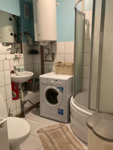 uma casa de banho com uma máquina de lavar roupa e um WC em Apartamenti em Cēsis