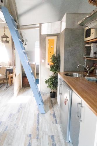 une cuisine avec une échelle bleue sur le mur dans l'établissement Honfleur location, à Honfleur