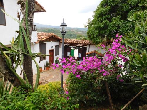 una casa con fiori rosa e un lampione di Tinto Hostel a Barichara