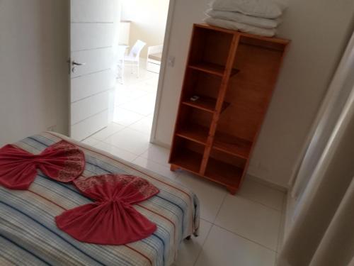 a bedroom with a bed with red pillows on it at Apartamento 150m da praia de Canoa Quebrada in Canoa Quebrada