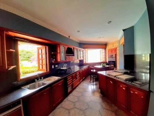 a large kitchen with red cabinets and a window at Casa Veraneras de San Fernando in Cali