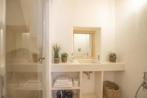 une salle de bain avec un lavabo et un miroir dans l'établissement CASA FLAMÌ 2, à Ostuni
