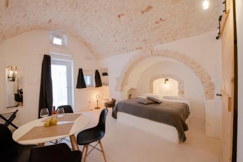 1 dormitorio con 1 cama, mesa y sillas en CASA FLAMÌ 2 en Ostuni