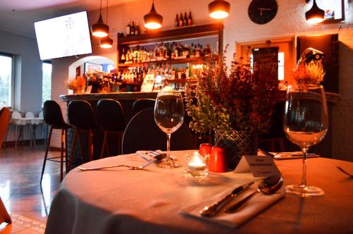 a table in a restaurant with two wine glasses at Tailor Hotel Sport & Conference in Morąg