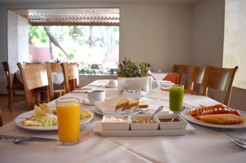 a table with plates of food and glasses of orange juice at Hotel Palacio Azteca in Tijuana