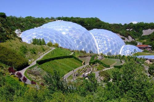 three domes of greenhouses on a hill with a garden at Sea Breeze Apartment in St Austell
