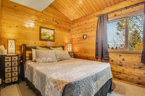 ein Schlafzimmer mit einem Bett und einem Fenster in der Unterkunft Aspen Hideaway Cabin in Garden City