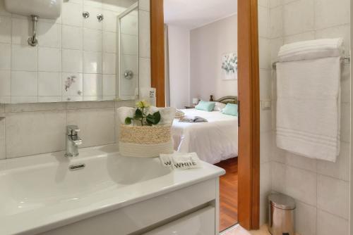 a bathroom with a sink and a bedroom with a bed at Plaza Rooms Ciampino in Ciampino