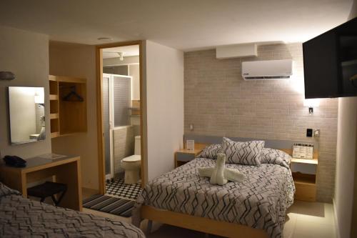 een kleine kamer met een bed en een badkamer bij El Suburbio - Morelos Sur in Morelia