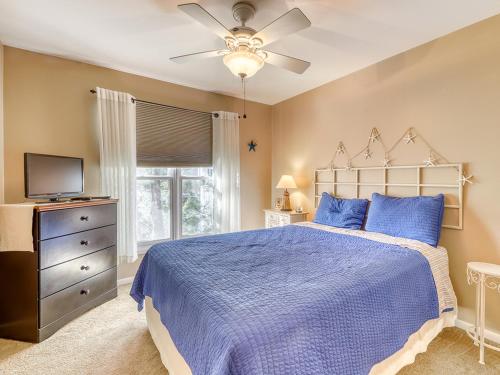 - une chambre avec un lit bleu et un ventilateur de plafond dans l'établissement Sea Colony - Lakeshore, à Bethany Beach